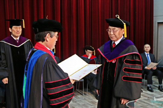 이봉관 서희건설 회장(오른쪽)이 14일 충남 천안 나사렛대에서 임승안 나사렛대 총장(왼쪽)으로부터 명예 재활학 박사 학위를 전달받고 있다.     서희건설 제공